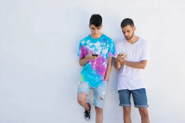 Sokak Duvarında Cep Telefonu Olan Gençler — Stok fotoğraf