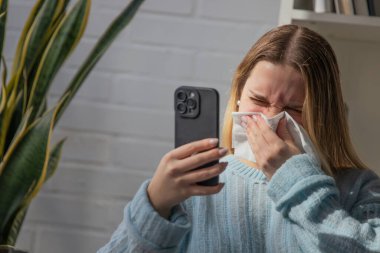 20 'li yaşlarda, soğuk, cep telefonu kullanan genç bir kadın.