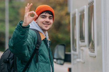 young man or traveler with backpack waving