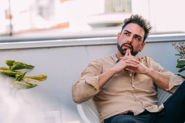 Evin terasındaki düşünceli genç adam.