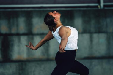 Dışarıda spor yapan genç bir kadın.