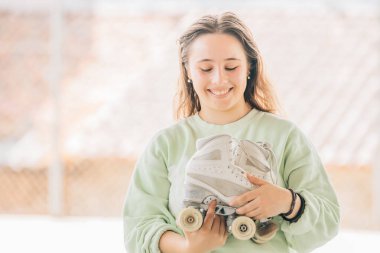 Patenleriyle dışarıda gülümseyen artistik patinaj sporcusu