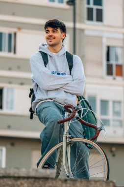 Sokakta dikey bisiklet süren genç bir adam ya da öğrenci.