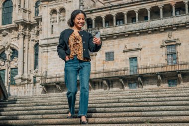 Kültürel bir gezide cep telefonlu genç Latin Amerikalı kadın.