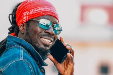 Sokakta cep telefonuyla konuşan Afrikalı bir adam