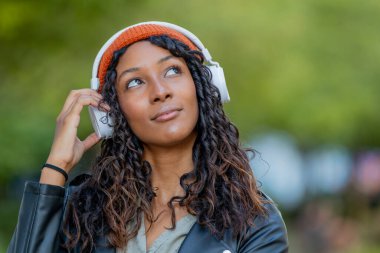 Kulaklıklı güzel bir Latin kadının portresi.