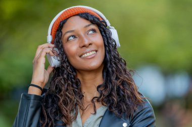 Kulaklıklı güzel bir Latin kadının portresi.