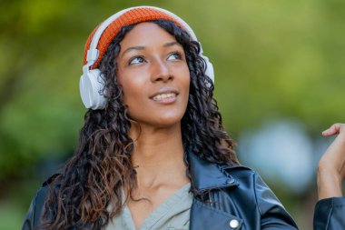 Kulaklıklı güzel bir Latin kadının portresi.