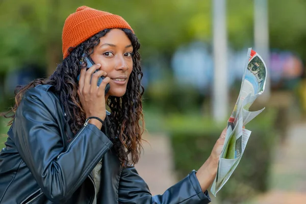 Haritalı kadın gezgin cep telefonuyla konuşuyor