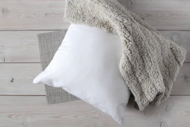 Beyaz yastık ve yumuşak halı ahşap yüzeyde. 