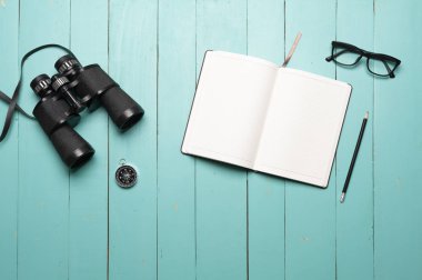 Seyahat, defter ve harita, yolculuk, bul ve arama kavramı ile yeşil ahşap zemin üzerinde dürbün planlayın.