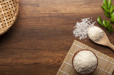 Yasemin pirinç bir kase ve tahta kaşıkla üstten görünüm kavramı pişirme koyu ahşap tablo.