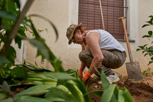 Idős nő dolgozik a kertben lapáttal — Stock Fotó
