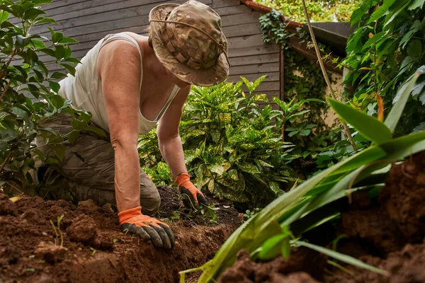 Mujer mayor trabajando en el suelo en el jardín — Foto de Stock