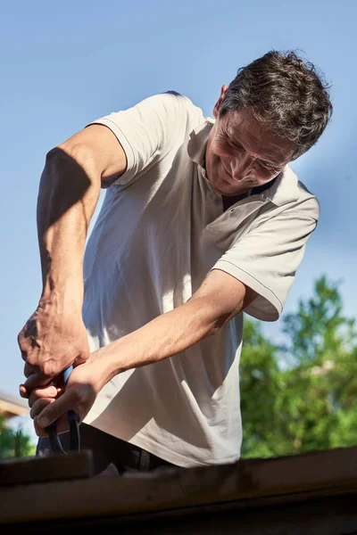 Homem idoso ativo na aposentadoria trabalhando no quintal, sorrindo — Fotografia de Stock