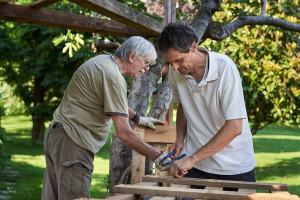 Активні старші чоловіки працюють на задньому дворі — стокове фото