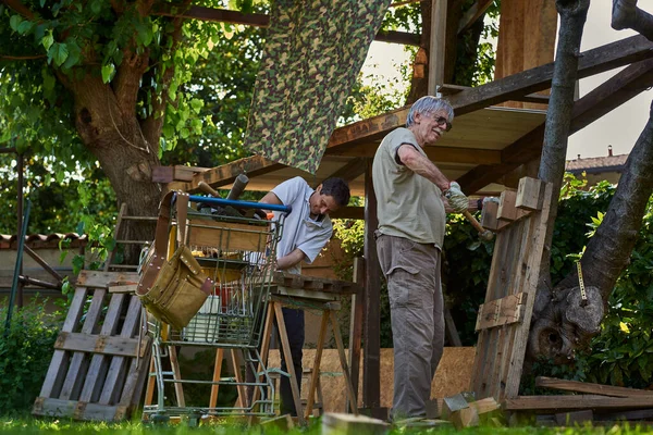 Hombres mayores activos trabajando en el patio trasero — Foto de Stock