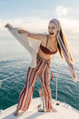 lüks şık genç bir kadın moda pantolon yüzer Karayip Denizi üzerinde beyaz onun yatta sahiptir bir zengin yaşam ve tatil