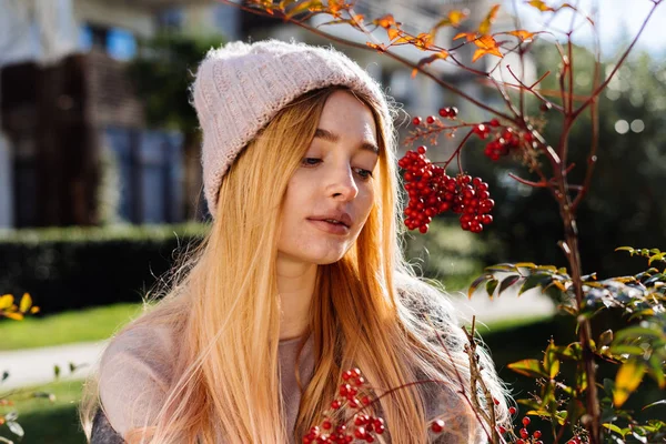 Söt ung blond tjej i en rosa hatt som njuter av det varma vårvädret, gå genom hennes trädgård — Stockfoto