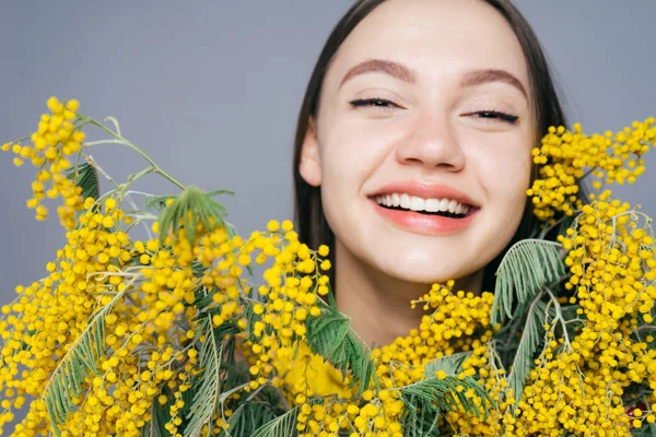 幸せな笑い若い女の手で黄色の香りのよいミモザを保持している春を楽しんで — ストック写真