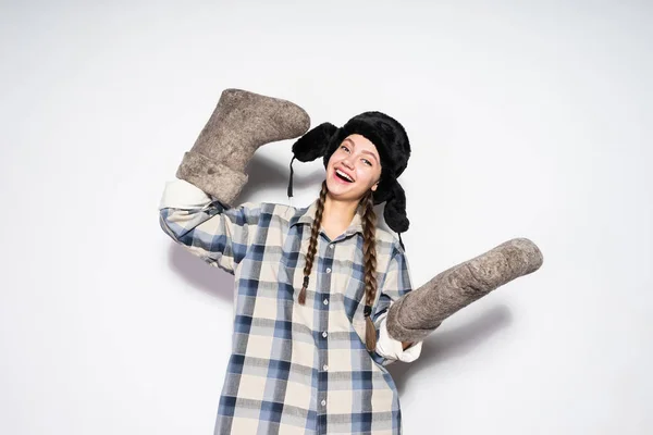 Mooie Russische vrouw houdt van grijze warme laarzen, camera kijken en lachen — Stockfoto
