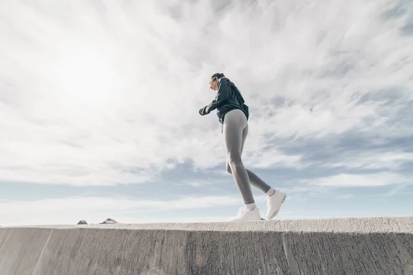En självsäker stark tjej går för sport och leder en hälsosam livsstil, jogga runt havet — Stockfoto