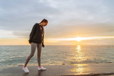 gün batımında, deniz kenarında eğitim sonra dinlenme genç ince kız yol açar bir aktif ve sağlıklı yaşam tarzı