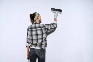 duvarlar bir spatula ile tesviye genç bir kız onun evinde onarım işi ekose gömlekli
