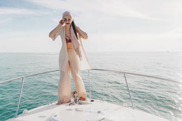 Elegant stylish girl in sunglasses posing on a white yacht, went on a sea voyage — Stock Photo, Image