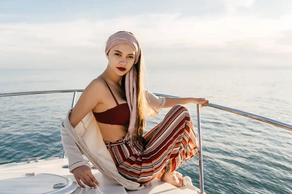 Mooie meisje in stijlvolle zomer kleding zit op een witte jacht, ging op een zeereis, op vakantie — Stockfoto