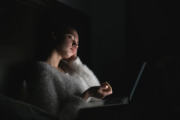 Gece geç saatte yatakta oturuyor ve onu laptop, sıkıcı bir film izlerken genç kız uyuya — Stok fotoğraf