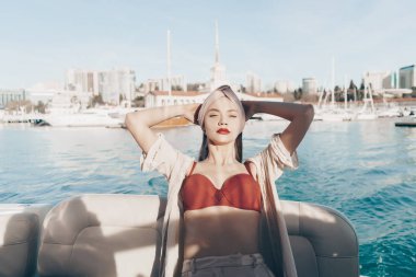 şık yaz giysileri lüks bir güzel kız onun beyaz yatta rahatlatır, adalarda tatil yelken