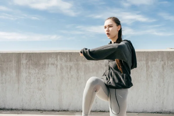 Chica atlética resistente haciendo ejercicios, flexionar los músculos antes de hacer ejercicio al aire libre — Foto de Stock