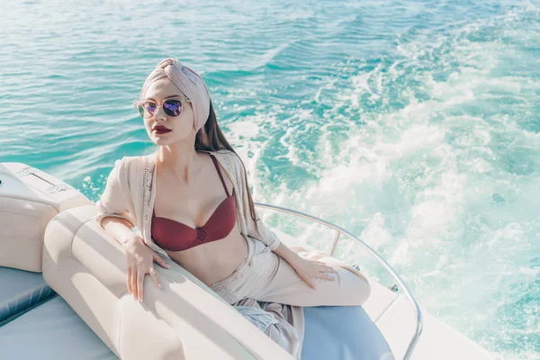 Lujosas mujeres ricas en gafas de sol están descansando y relajándose en su yate blanco, viaje por mar —  Fotos de Stock