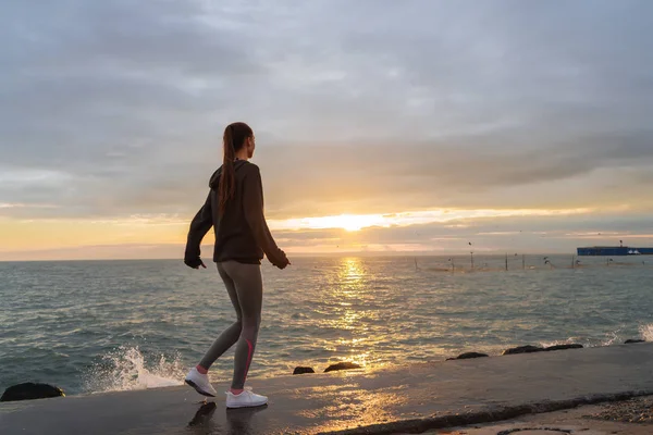 Atletica slanciata ragazza che corre in riva al mare al tramonto, vuole perdere peso — Foto Stock