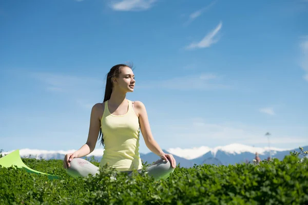 Mírové mladá dívka medituje a relaxuje na zelené trávě v parku, dělám jógu — Stock fotografie