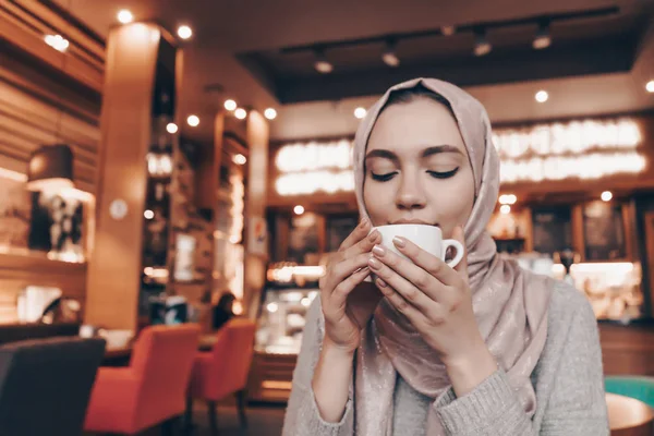 かわいいアラブ女の子ヒジャーブ居心地のよいオリエンタル レストランでコーヒーを飲む — ストック写真