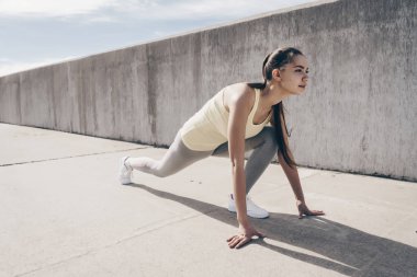 spor yaparken güçlü bir genç kız açık havada, bir uzun mesafe çalıştırmak hazır