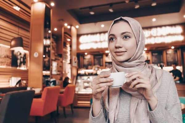 Gyönyörű fiatal Arab lány fejkendő keleti kávézóban aromás kávét iszik — Stock Fotó