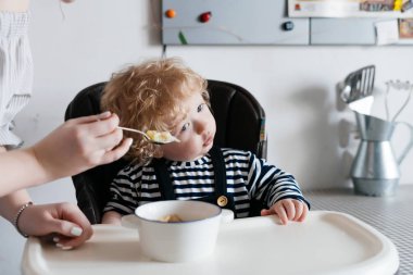 bakım genç bir anne küçük kıvırcık oğlu beslemeleri yararlı çorba kaşığı ile birlikte öğle yemeği