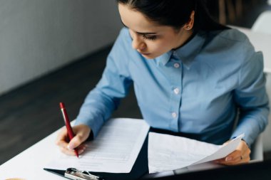 mavi gömlekli odaklı genç kız serbest meslek inşaat, belgeleri doldurur