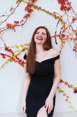 dinlenme zevk çekici kızı duvara onun bahçesinde poz siyah elbiseli gülüyor