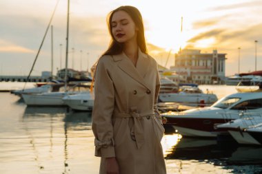 Siperdeki bir liman içinde akşam güneş ışınlarının poz şık bej uzun saçlı güzel kız