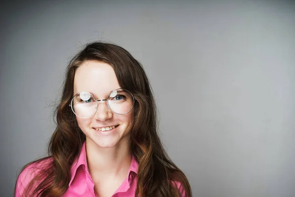 Bela jovem trabalhador de escritório em uma camisa rosa e óculos sorrindo e olhando para a câmera — Fotografia de Stock