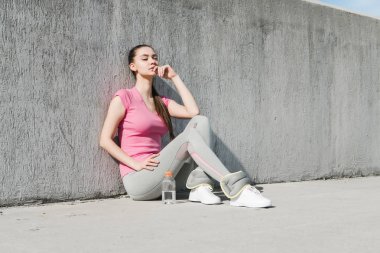 eğitimden sonra güç kazanıyor açık havada, yerde oturan huzurlu genç kız