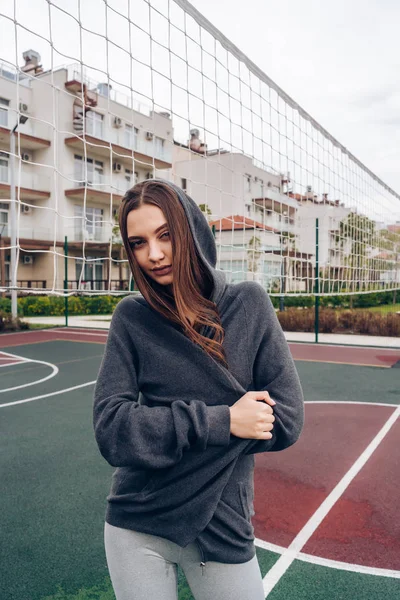 Zeker jong meisje doen oefeningen, die zich voordeed op outdoor sportveld — Stockfoto