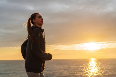 atletik genç kız deniz kıyısında günbatımı, istiyor kilo vermek için çalışır.