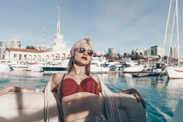 Elegante chica de lujo en gafas de sol se relaja y descansa en un yate, navega en el mar Caribe —  Fotos de Stock