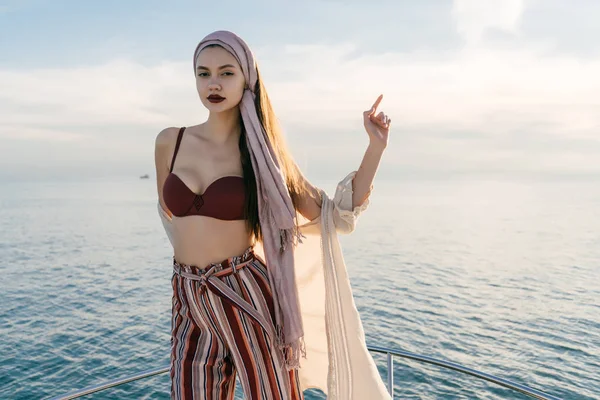 A fényűző fiatal lány pózol egy jachton, elegáns nyári ruha élvezheti a nyaralás és a tengeri út — Stock Fotó