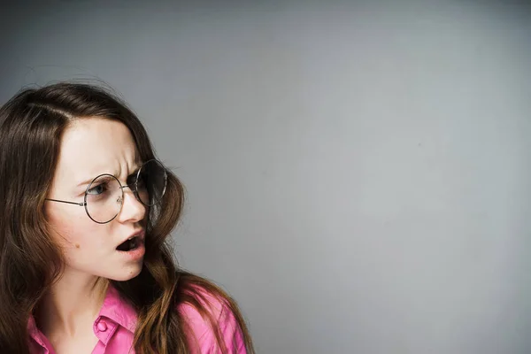 Недовольная грустная молодая женщина офисный работник в розовой рубашке и очках — стоковое фото